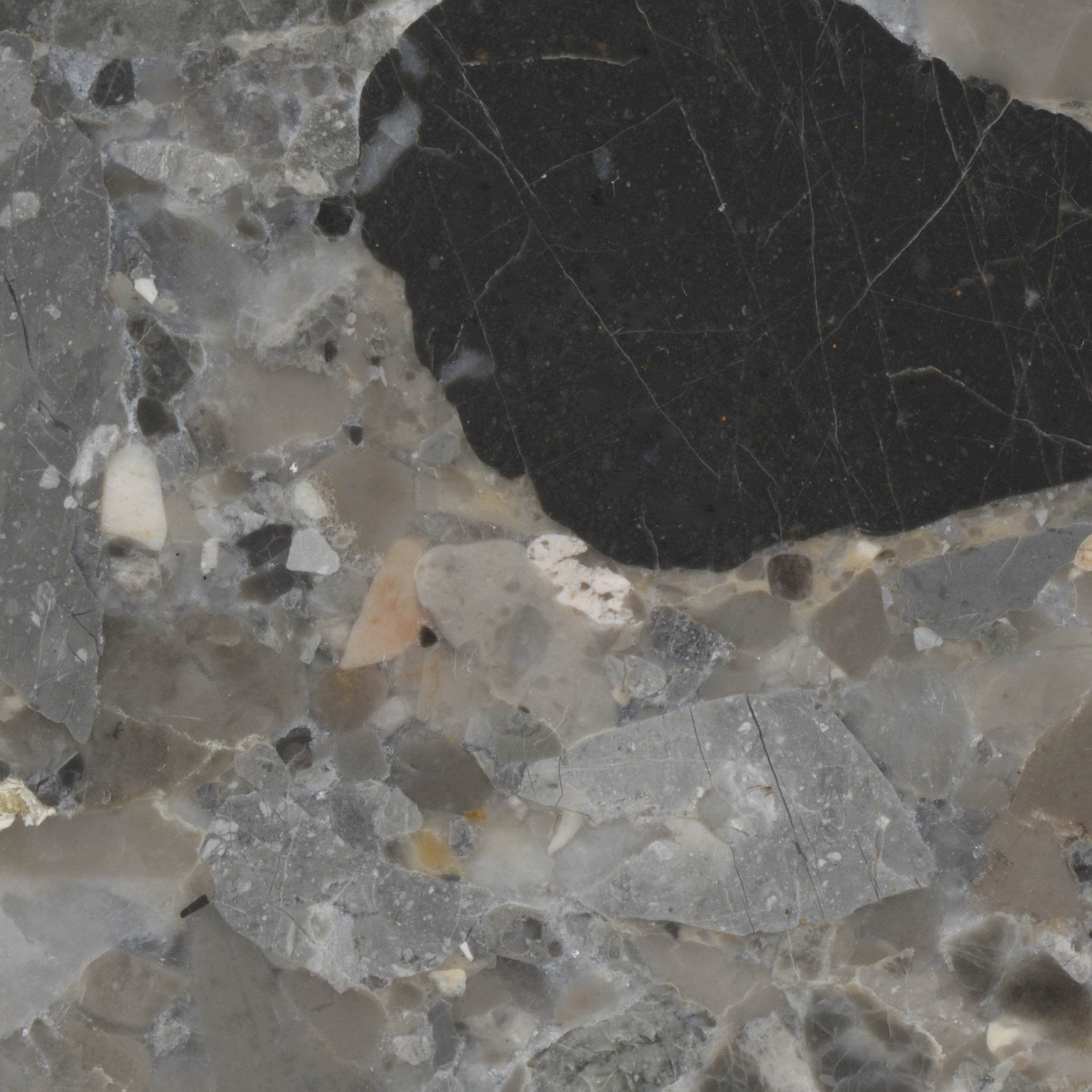 Downloadable high-resolution grey terrazzo style image, close-up detail of its varied angular stone fragments including black, white, and veined grey pieces, for digital printing systems.